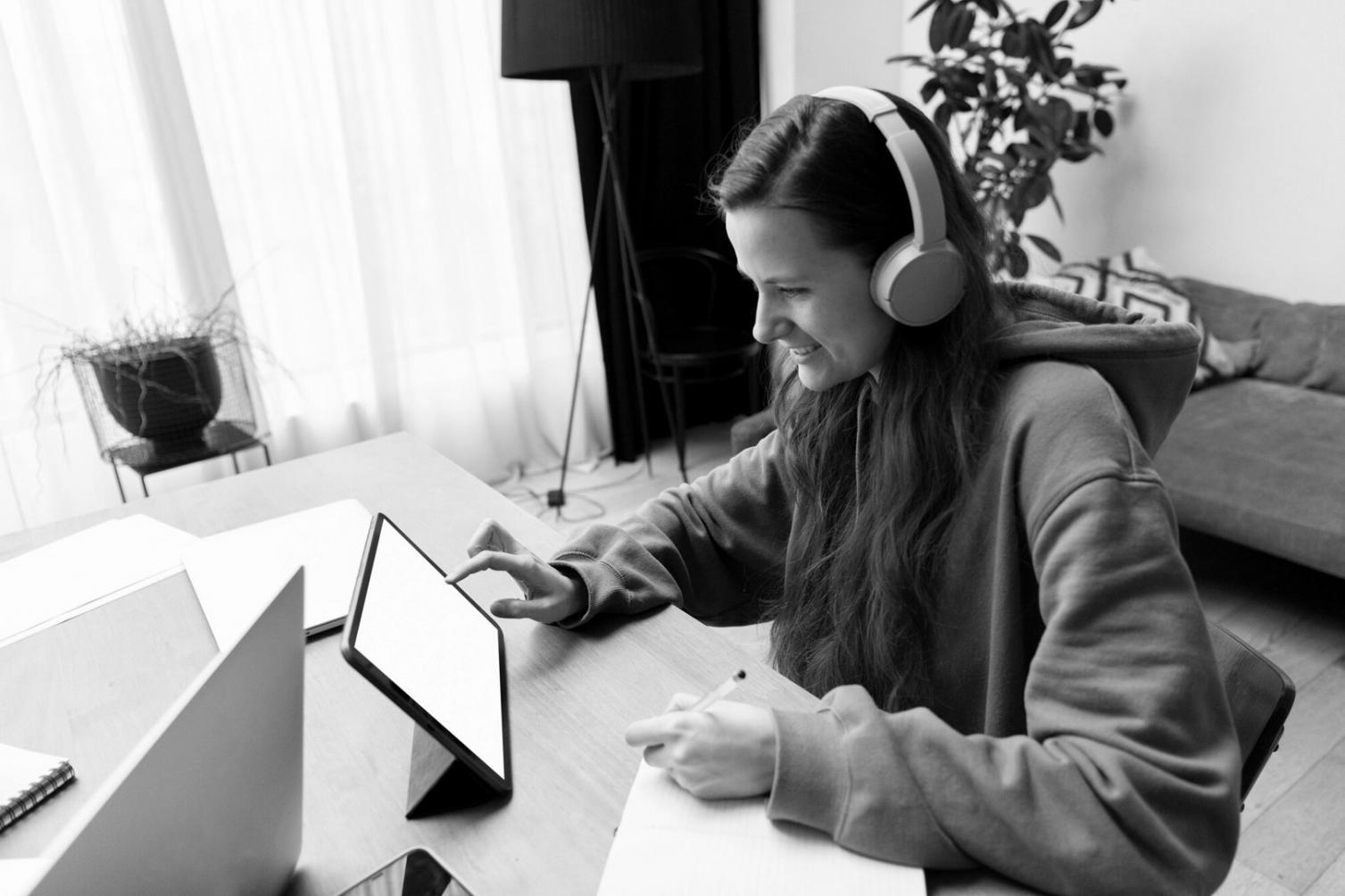 Student workspace with laptop displaying mobile game analytics dashboard and smartphone showing campaign performance